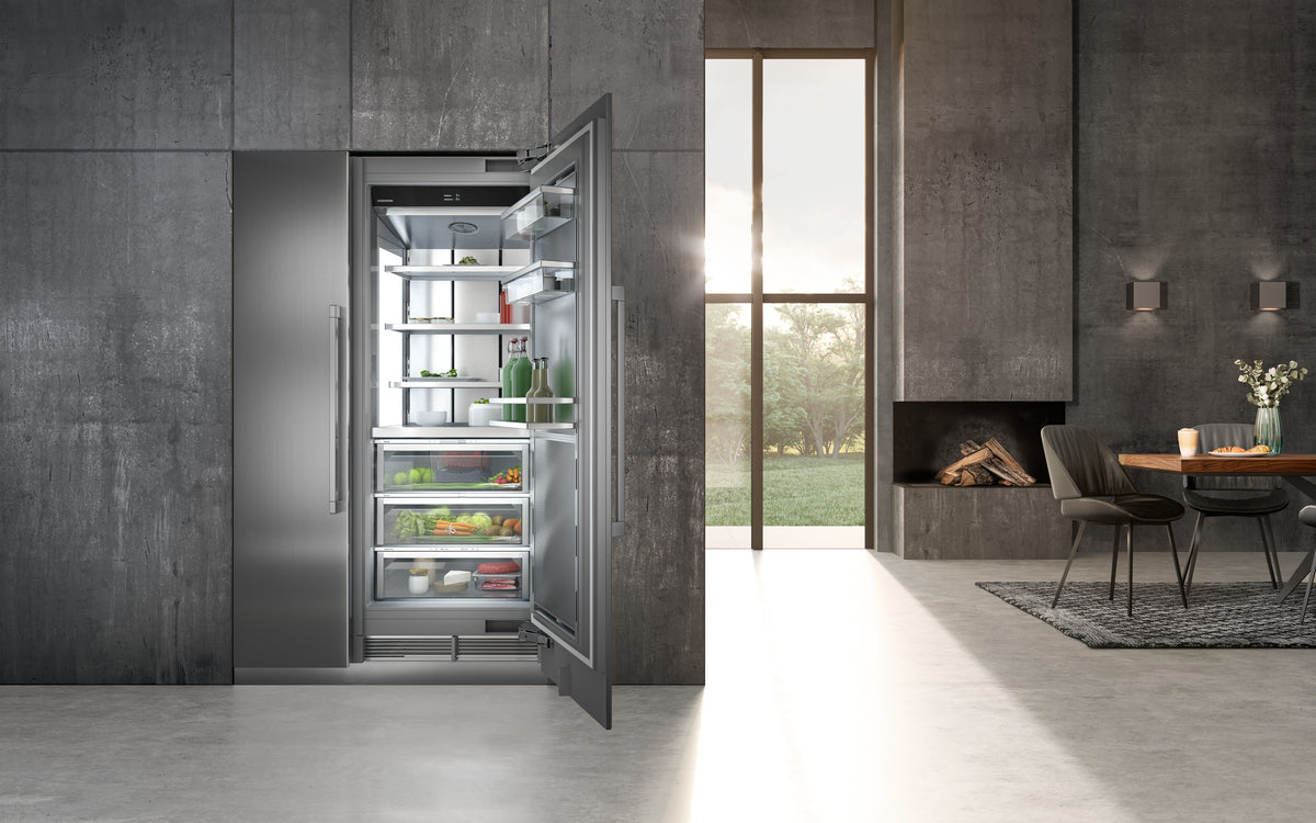 Réfrigérateur Liebherr Monolith ouvert dans une cuisine aux murs de béton sombre