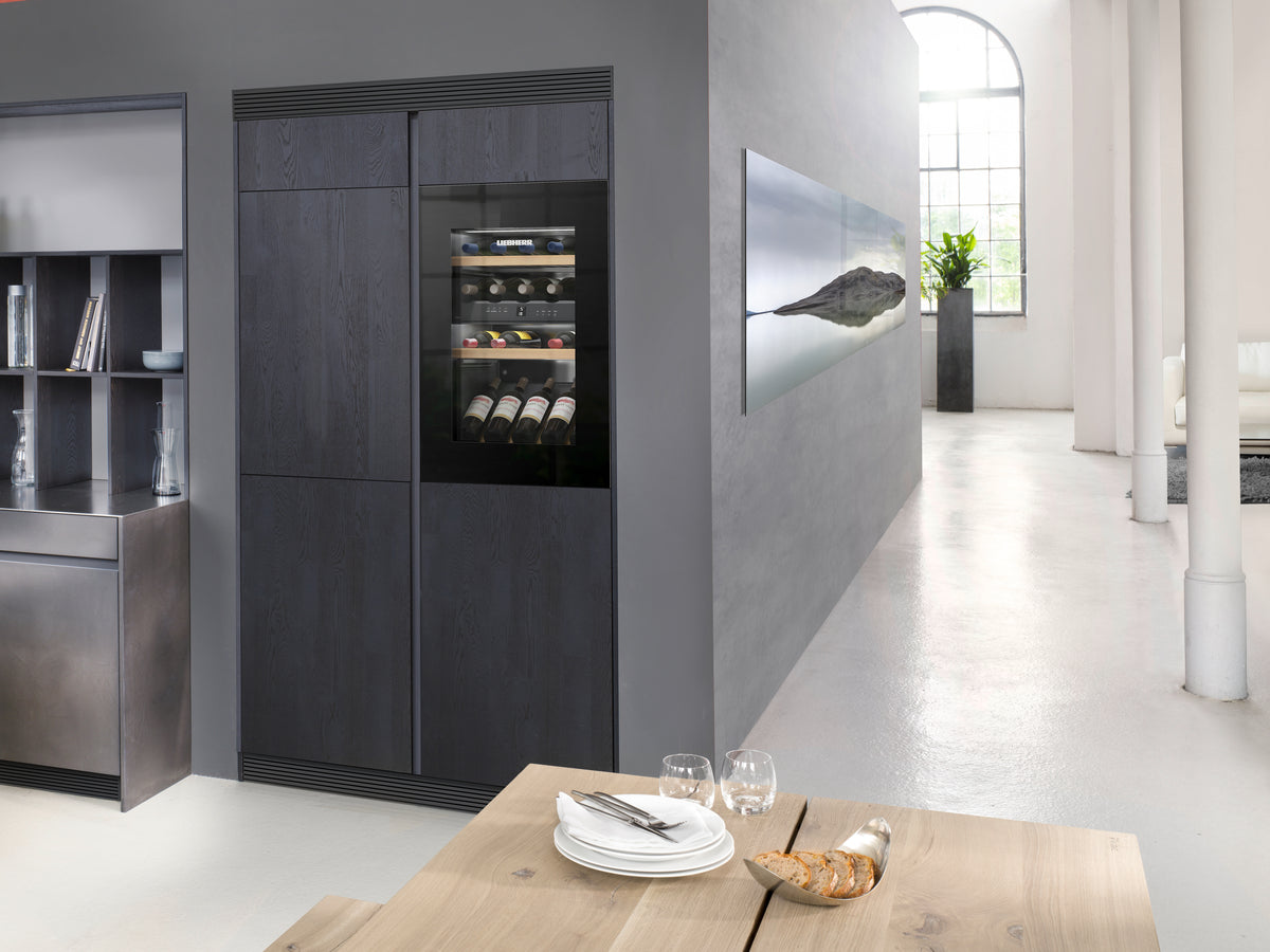 Cave à vin encastrable Liebherr Vinidor en verre noir intégrée dans une cuisine aux façades sombres
