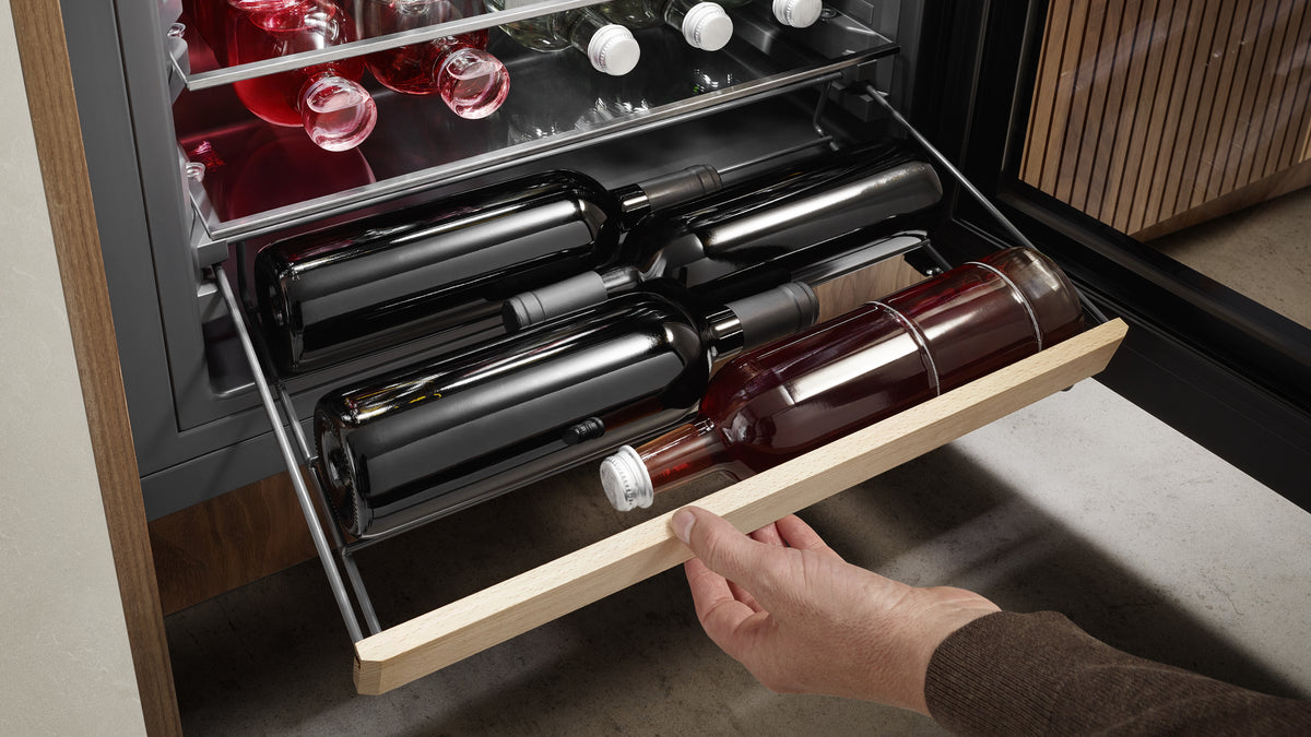 Clayette coulissante en bois garnie de bouteilles couchées dans un réfrigérateur à boissons Liebherr