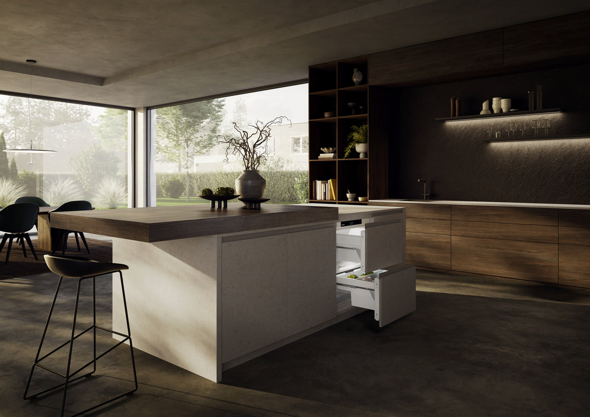 Îlot de cuisine avec tabourets et réfrigérateur sous plan Liebherr à tiroirs ouverts