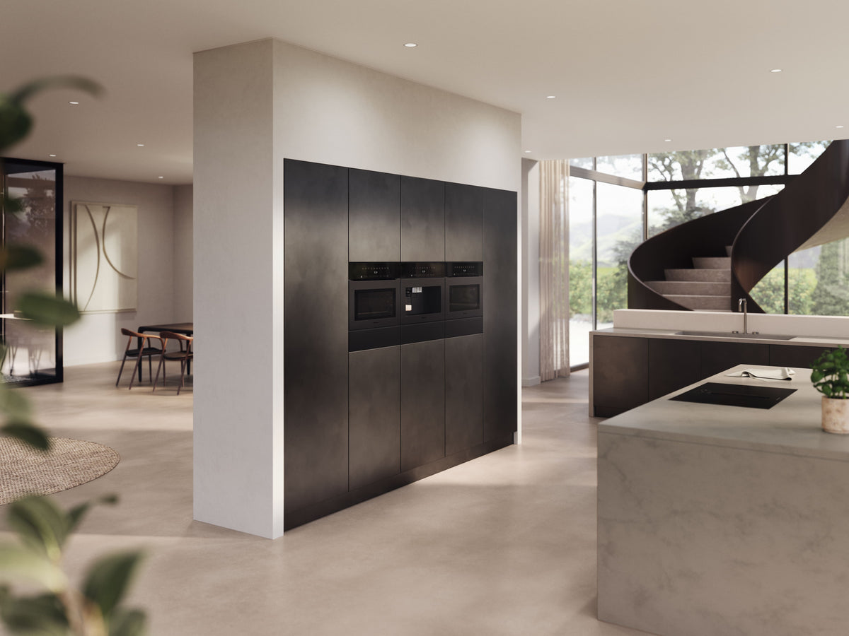 Appareils encastrables Miele noirs mats intégrés dans des colonnes sombres, au cœur d’une cuisine lumineuse