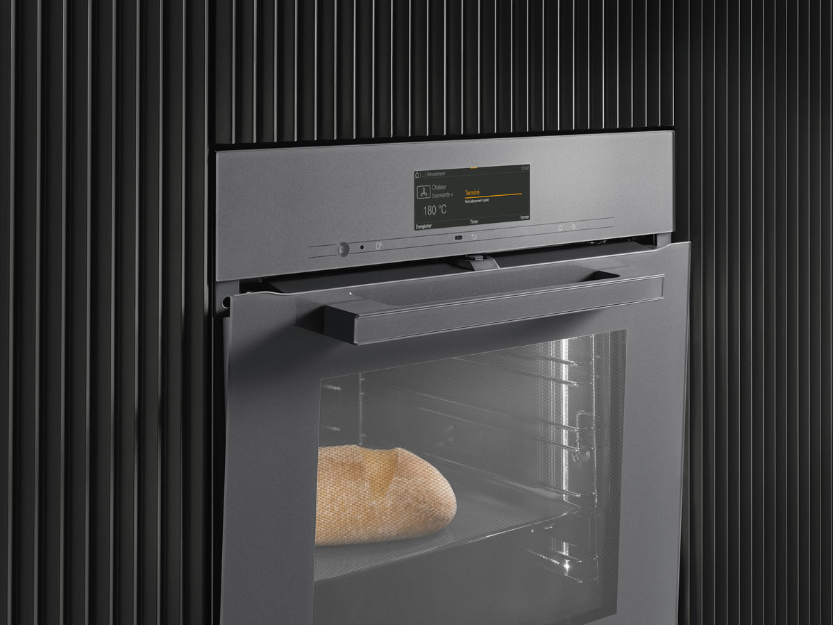 Four encastrable Miele gris graphite, pain doré derrière la porte vitrée