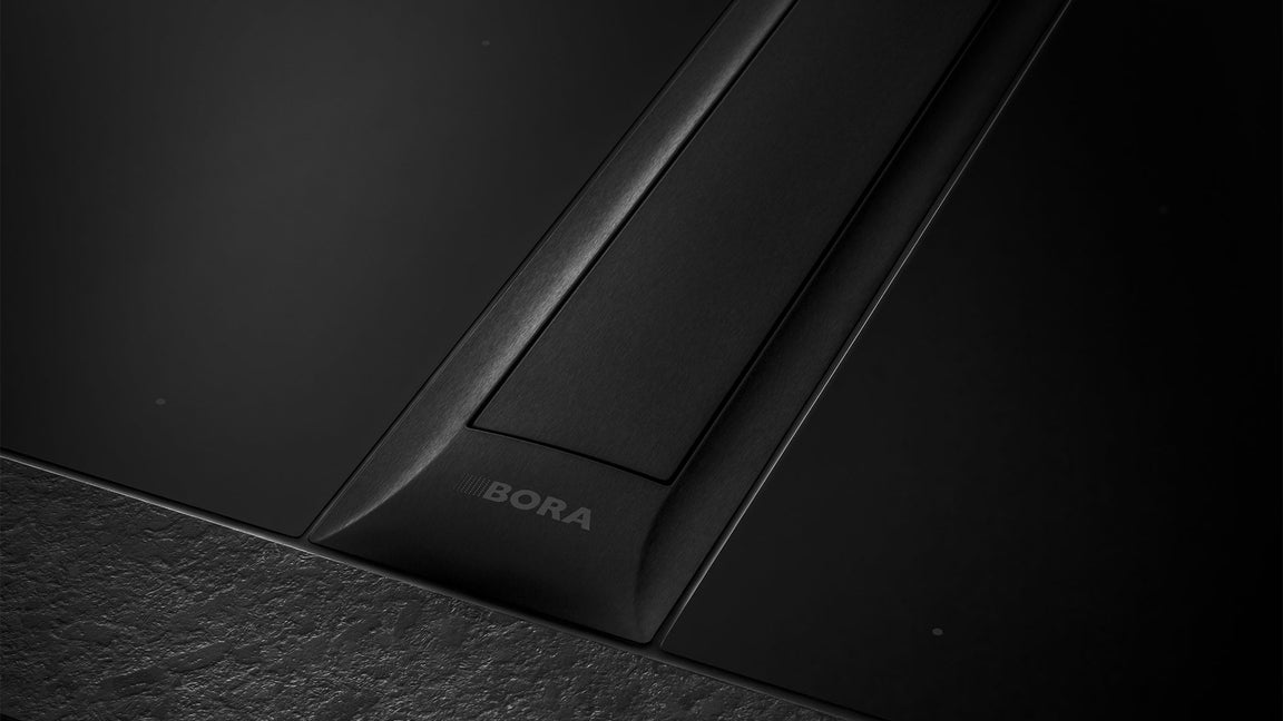 Système BORA Professional 3.0 All Black : tables à induction et dispositif aspirant noir sur un plan de travail sombre