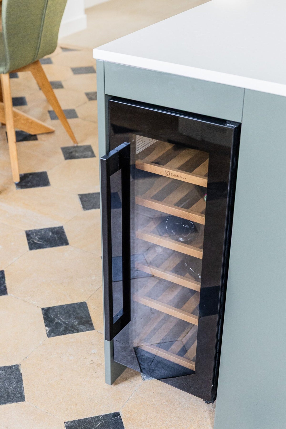 Cave à vin Electrolux intégrée dans un îlot de cuisine vert olive