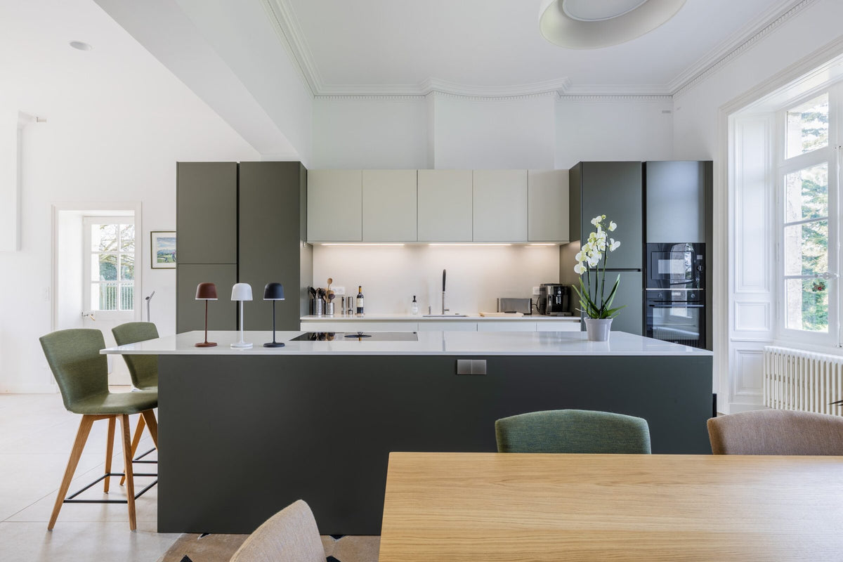 Îlot central vert olive avec plan de travail en Silestone Yukon et table de cuisson BORA