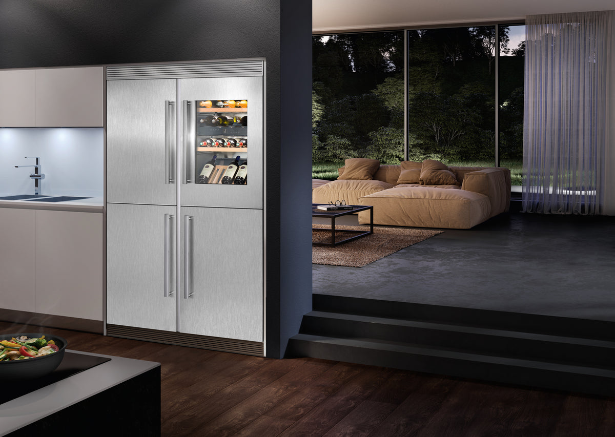 Cave à vin encastrable Liebherr Vinidor intégrée dans un alignement de colonnes inox, face au séjour