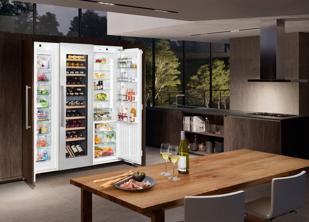 Colonnes Liebherr ouvertes, cave à vin au centre, dans une cuisine aux façades de bois sombre