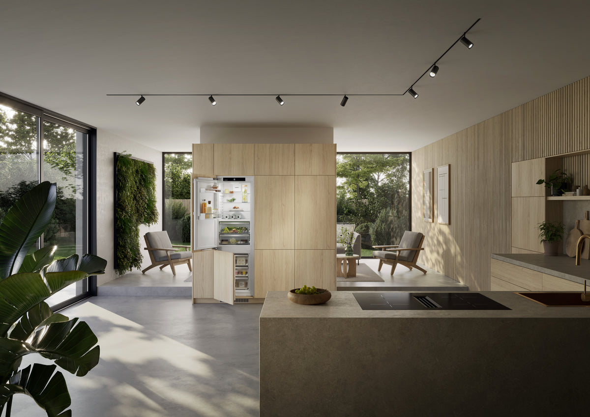 Combiné encastrable Liebherr intégré dans une colonne en bois clair, cuisine ouverte sur le séjour