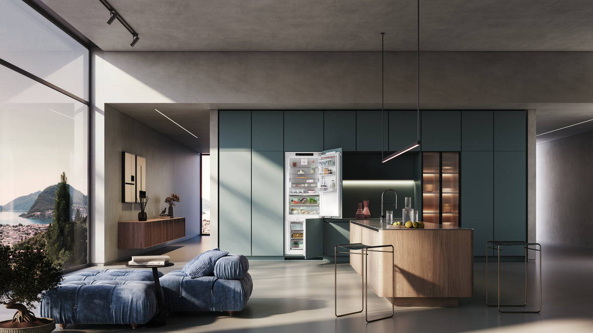 Combiné encastrable Liebherr ouvert dans une cuisine aux façades vert profond, face à un salon