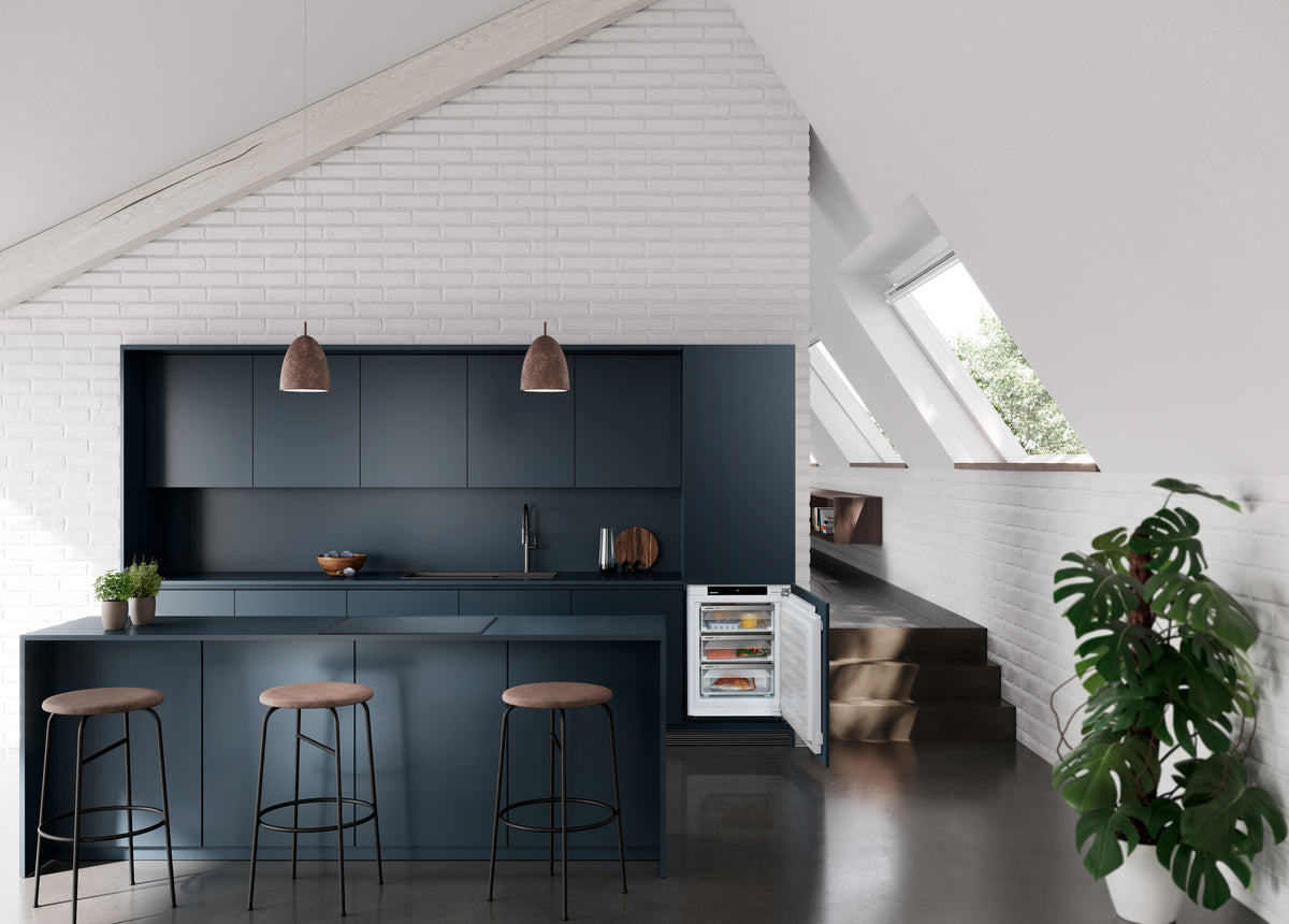 Cuisine bleu nuit sous les combles avec congélateur intégrable Liebherr ouvert