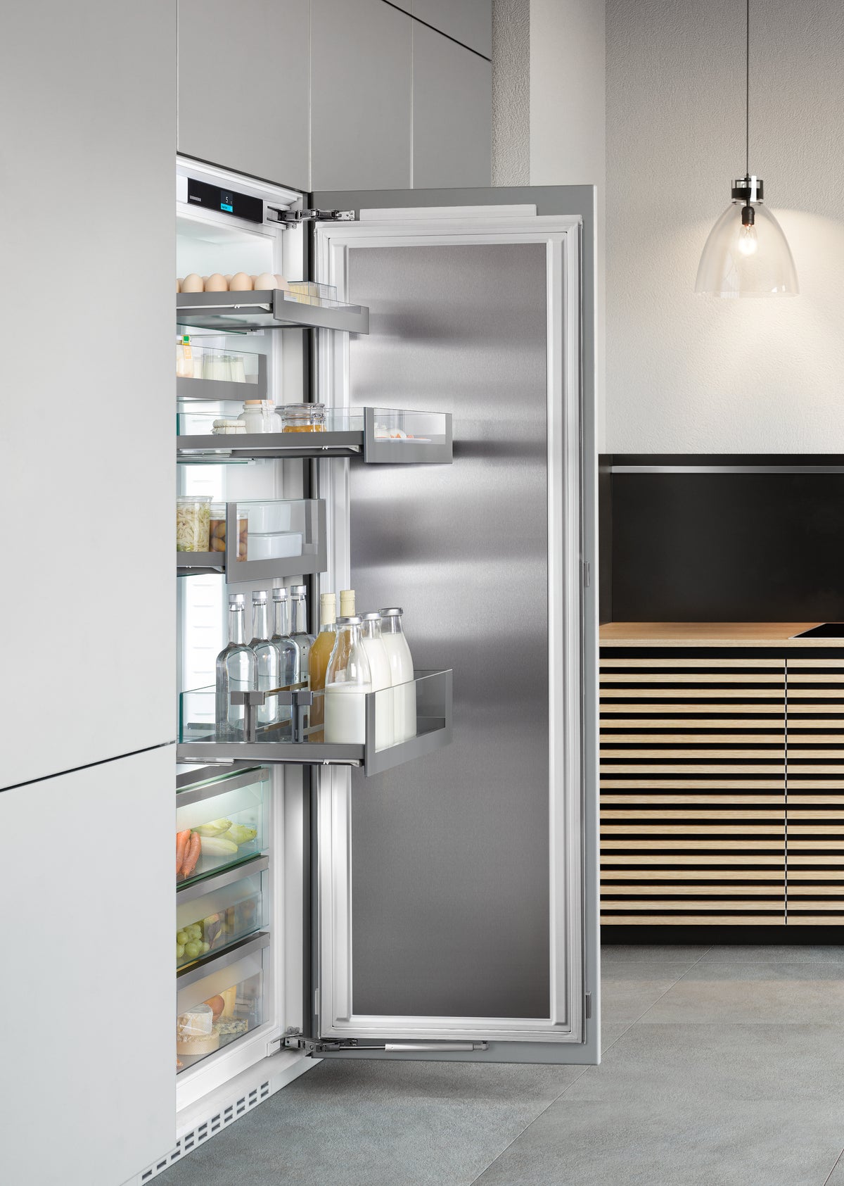 Colonne de cuisine grise avec réfrigérateur Liebherr ouvert, intérieur éclairé