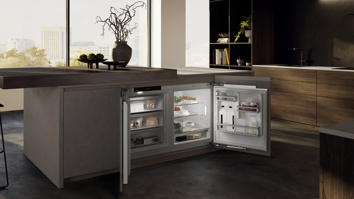 Îlot de cuisine avec congélateur et réfrigérateur sous plan Liebherr ouverts