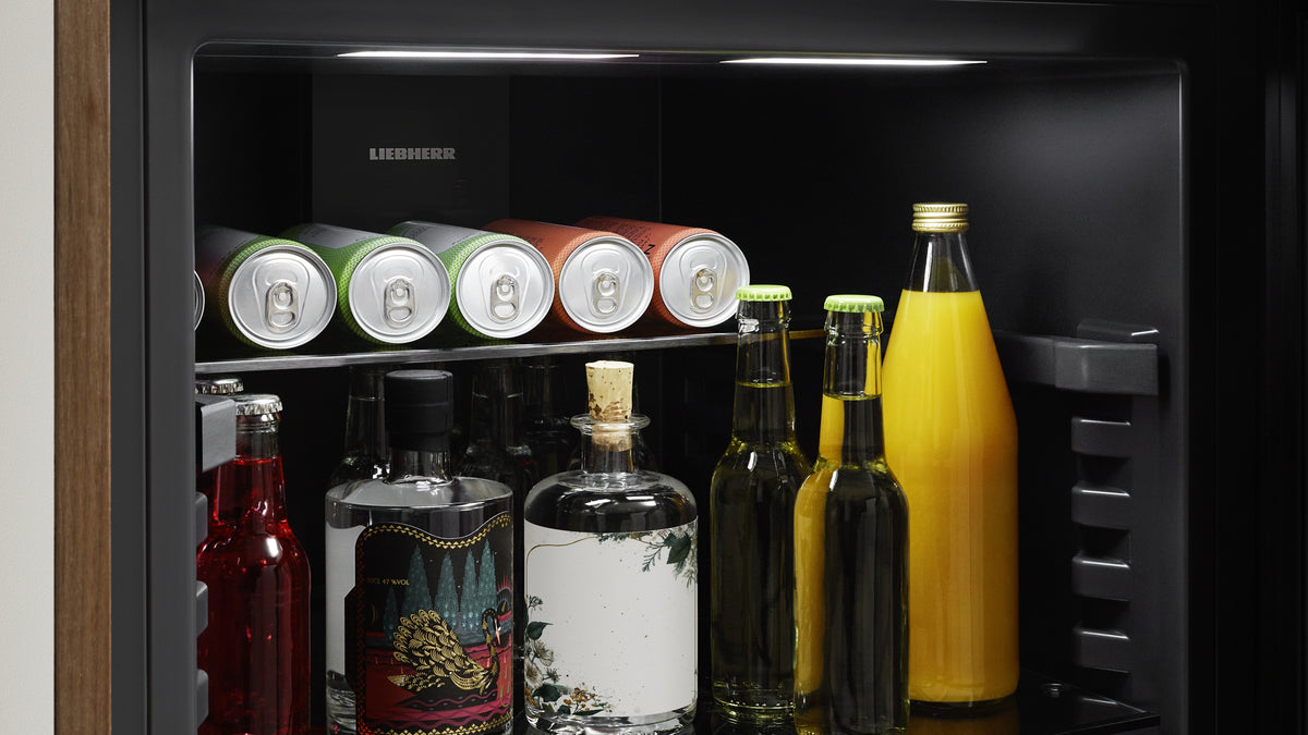 Clayette en verre divisible accueillant canettes et grandes bouteilles dans un réfrigérateur à boissons Liebherr