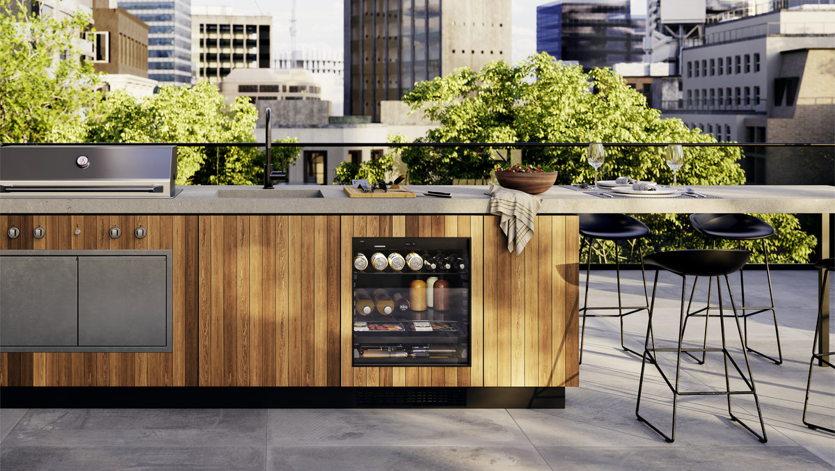 Îlot de cuisine d’extérieur en bois avec réfrigérateur Liebherr sous plan à porte vitrée