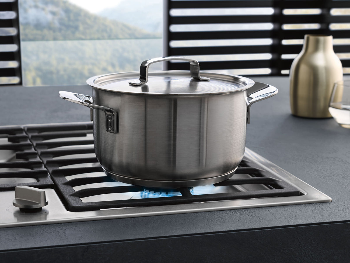 Faitout inox sur un brûleur allumé d’une table de cuisson au gaz Miele