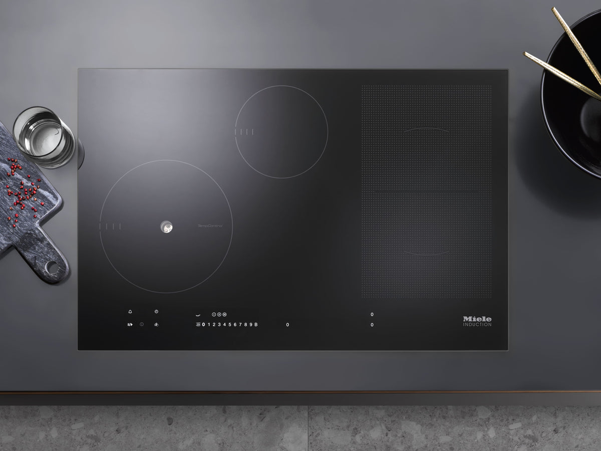 Table de cuisson à induction Miele vue de dessus, zone TempControl à l’avant gauche